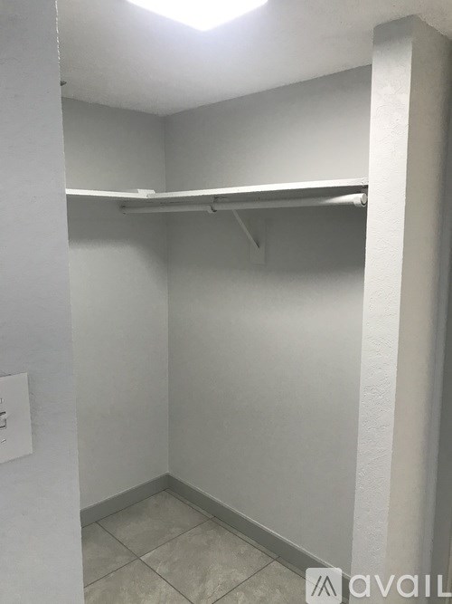 A small, empty room with a shelf and a light switch on the wall.