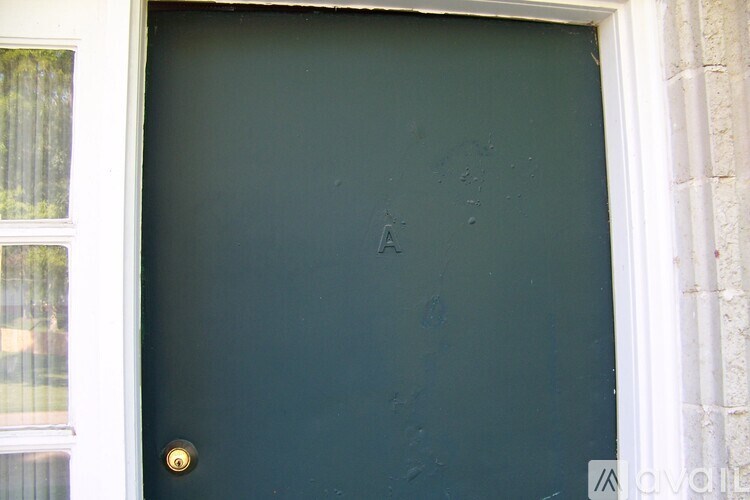 A black door with a gold handle and a white frame.