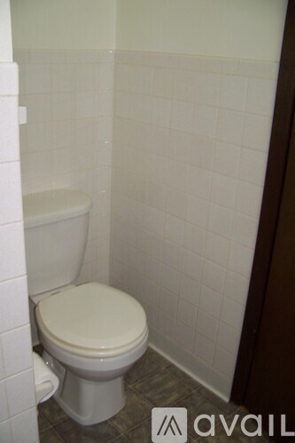 A white toilet in a tiled bathroom.