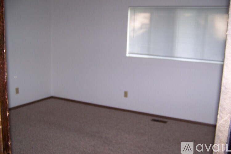A room with a window and carpeted floor.