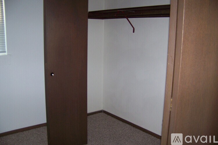 A brown closet with a hanger in it.