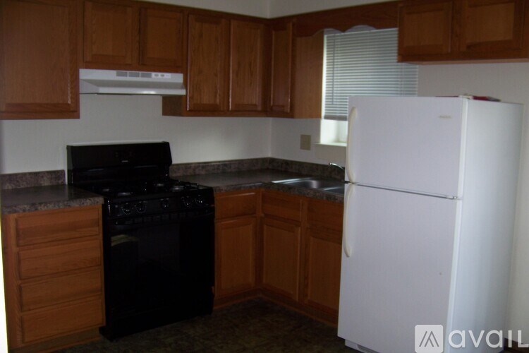 A kitchen with a black stove top oven and a white refrigerator.