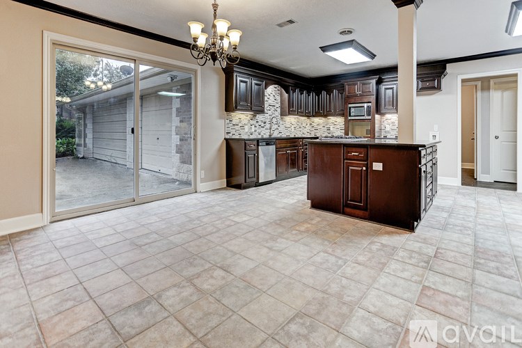 A large, empty room with a kitchen area in the background.