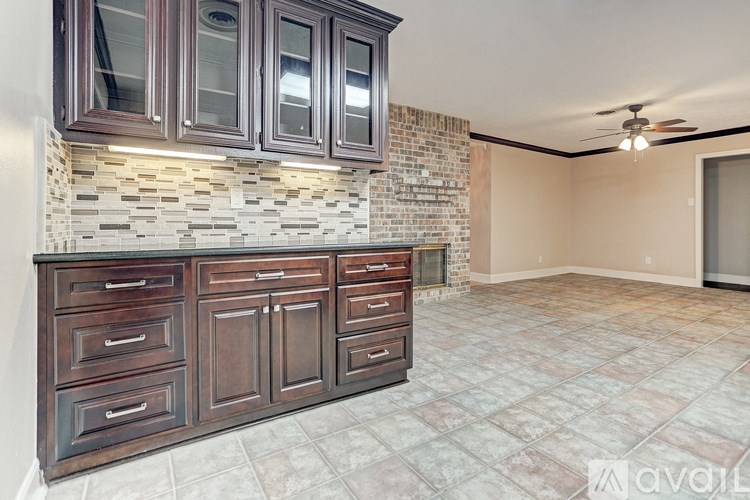 A kitchen with a tile backsplash and wooden cabinets.