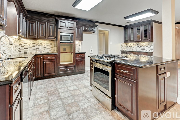 A kitchen with brown cabinets and a tile floor.