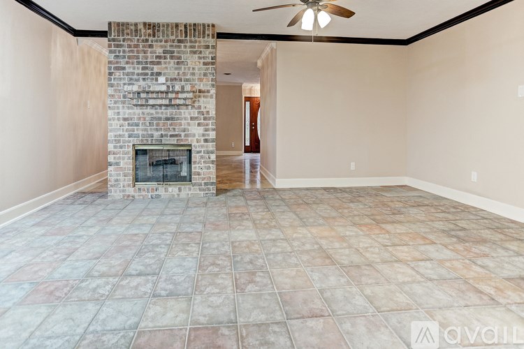 A room with a fireplace and a fan on the ceiling.