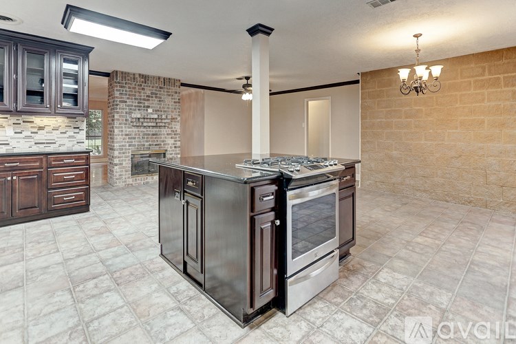 A kitchen with a black stove top oven and a tiled floor.