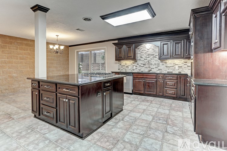 A kitchen with a large island and dark wood cabinets.