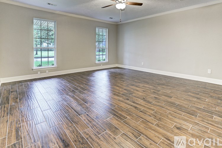 A room with wooden flooring and a ceiling fan.