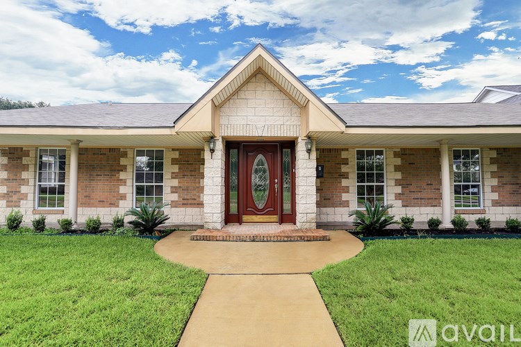 A house with a red door and a brown walkway in front.