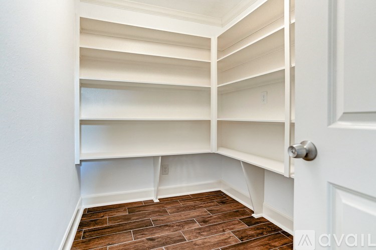 A white closet with a door and shelves.