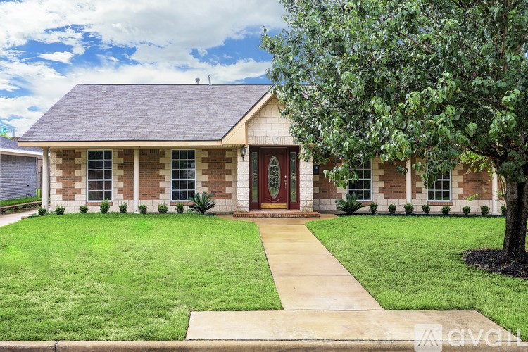 A house with a red door and a green lawn.