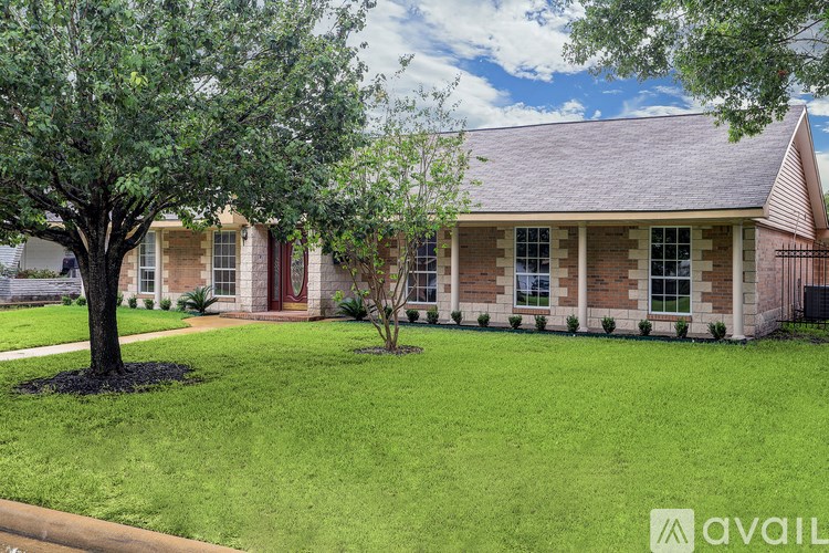 A house with a red door and a tree in front.