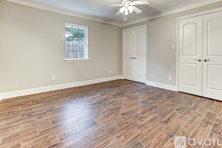 A room with wooden flooring and a ceiling fan.