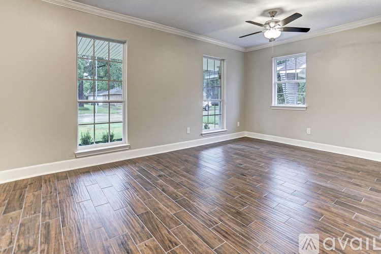 A room with wooden flooring and a ceiling fan.