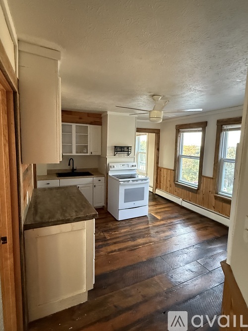 A kitchen with wooden cabinets and a white stove top oven.