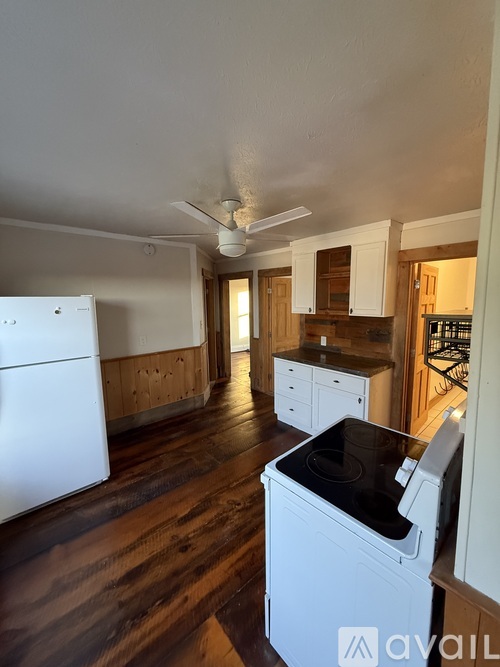 A kitchen with white cabinets and a wooden counter.