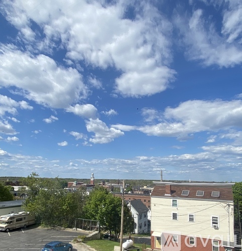 A view of a town with a large building in the foreground and a boat in the background.