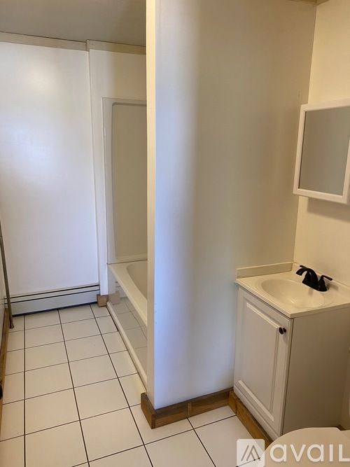 A bathroom with a sink, mirror, and shower.
