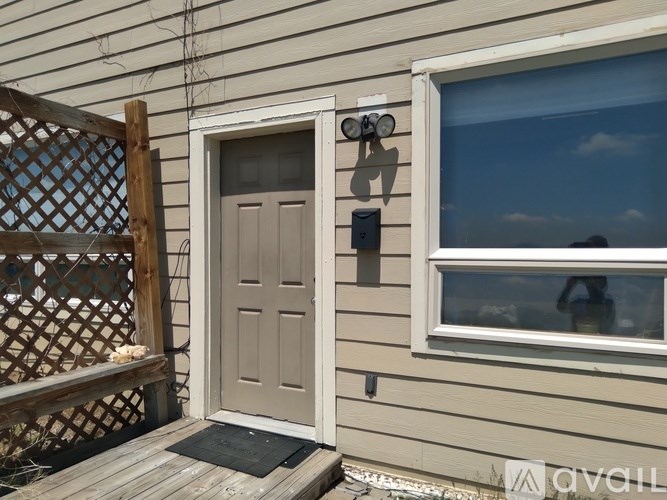 A house with a brown door and a window with a camera on it.