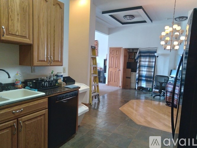 A kitchen with wooden cabinets and a black dishwasher.