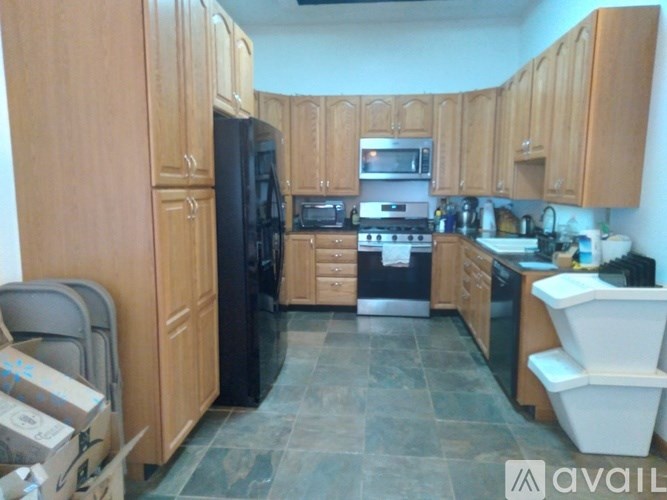 A kitchen with wooden cabinets and black appliances.