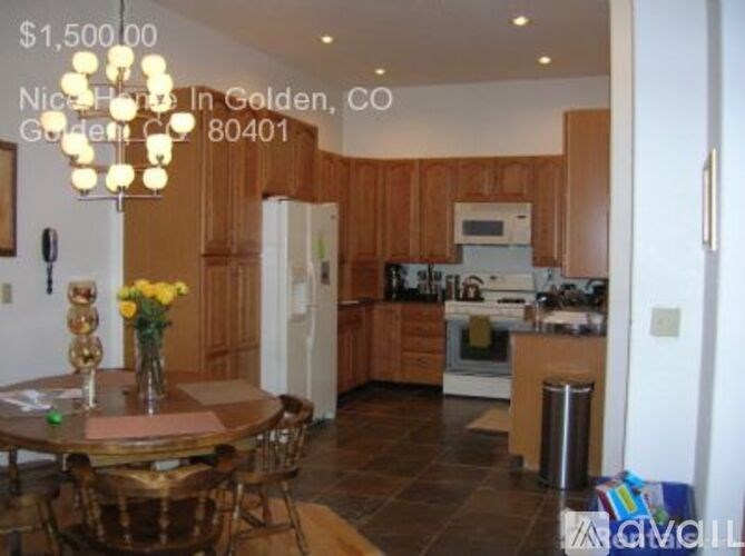 A kitchen with a table and chairs in front of it.