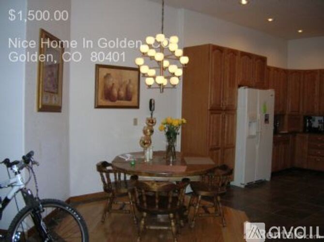 A dining room with a table set for two and a bicycle in the corner.