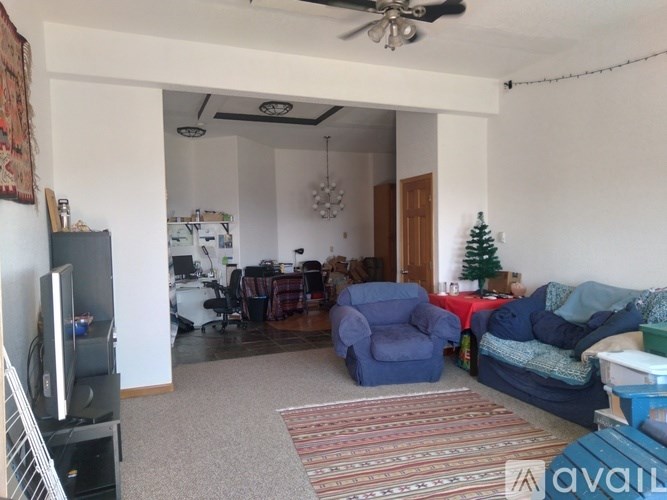 A living room with a television, a couch, and a rug.