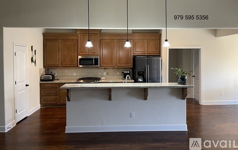A kitchen with wooden cabinets and a white island.