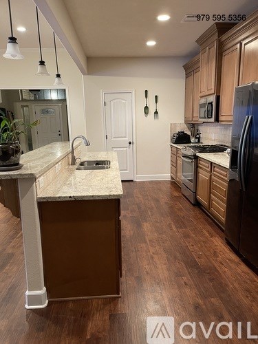 A kitchen with wooden floors and a marble island.
