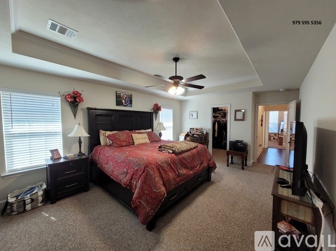 A bedroom with a large bed and a ceiling fan.
