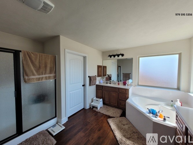 A bathroom with a tub, sink, and mirror.