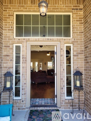 A house entrance with a glass door and a lamp on the side.