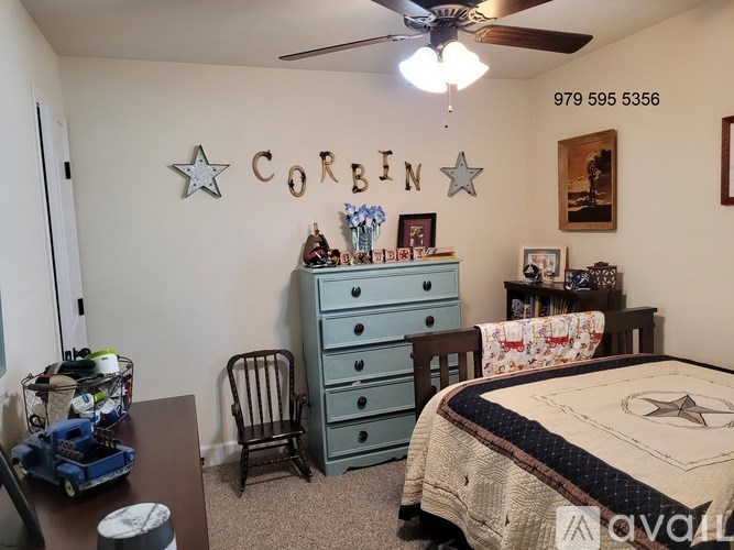 A room with a bed, dresser, chair, and a wall decorated with stars and the name "CORIN".