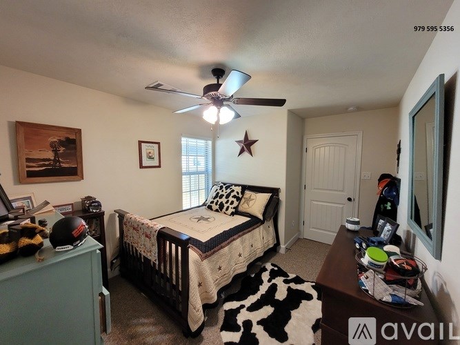 A bedroom with a bed, dresser, and a ceiling fan.