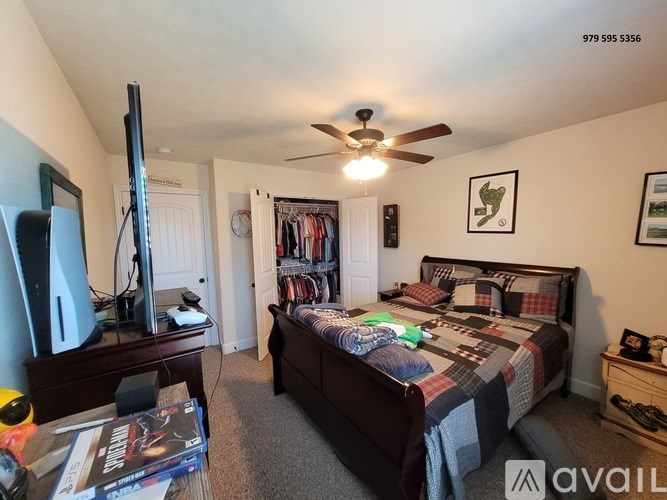 A bedroom with a bed, dresser, and a television.