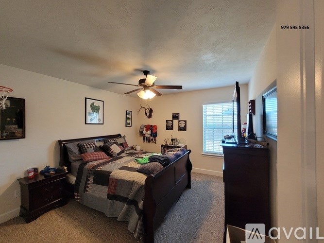A bedroom with a bed, dresser, and ceiling fan.