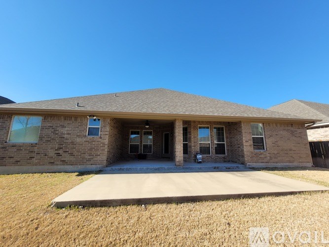 A house with a brown roof and a brick exterior is for sale.