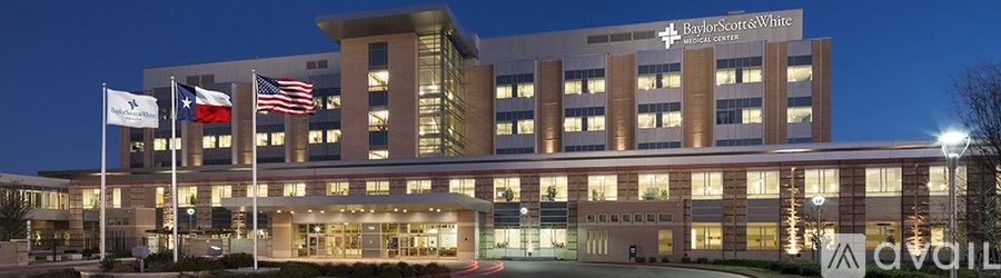 A large building with a Texas flag and an American flag in front of it.