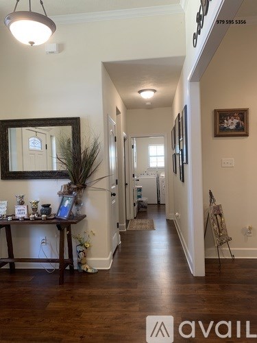 A hallway with a mirror and a table with vases on it.