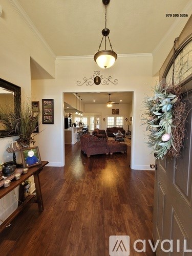 A living room with a Christmas wreath on the door.