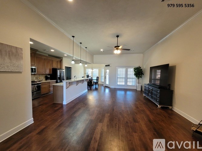 A spacious living room with hardwood floors and a ceiling fan.