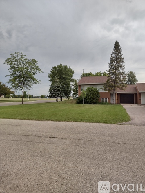 A house with a driveway and trees in front.