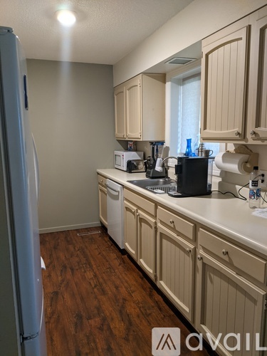 A kitchen with wooden floors and white appliances.