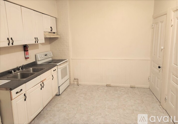 A kitchen with white cabinets and a sink.