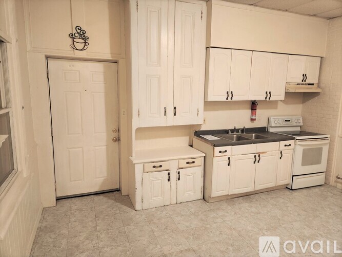 A kitchen with white cabinets and appliances.
