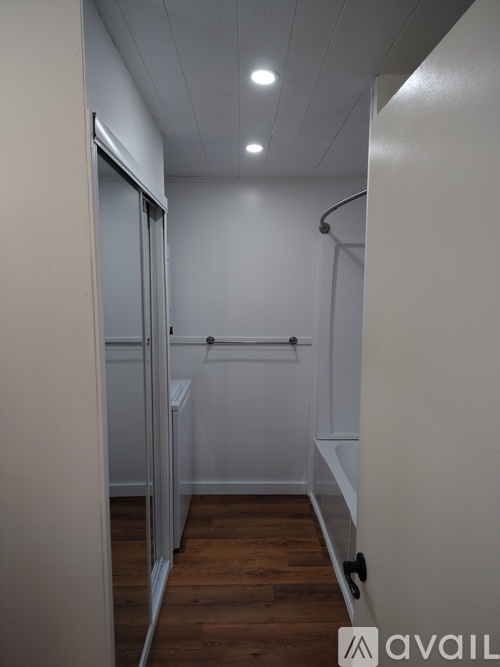 A long hallway with a carpeted floor and white walls.