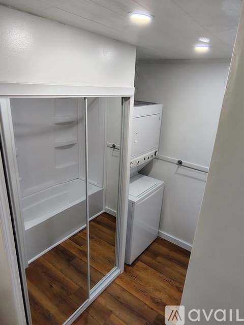 A hallway with a carpeted floor and a door at the end.