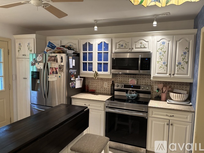 A kitchen with a refrigerator, oven, and microwave.